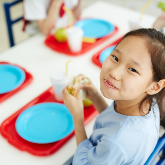 Smiling student eating sandwich